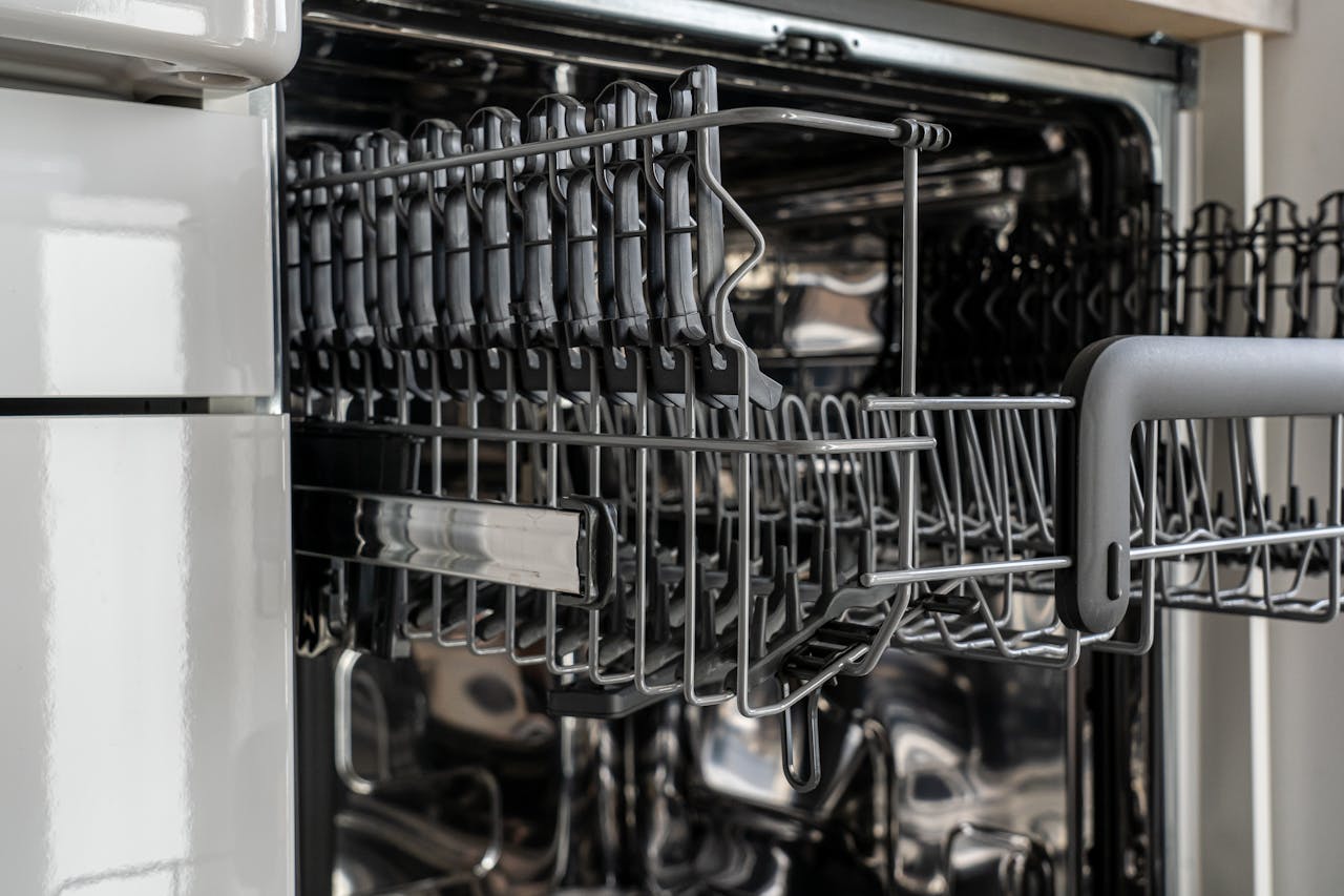 A detailed view of an empty modern dishwasher rack showcasing its stainless steel construction.